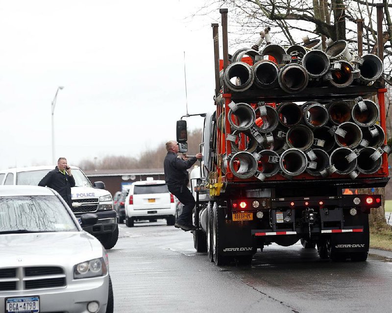 A truck delivers equipment that will be used to clear the Normans Kill after a landslide blocked a portion of the creek on Monday, April 20, 2015, in Albany, N.Y. A state of emergency has been declared after the landslide dammed up the creek, but officials say there's no immediate danger of flooding and no need for evacuations. (AP Photo/Mike Groll)