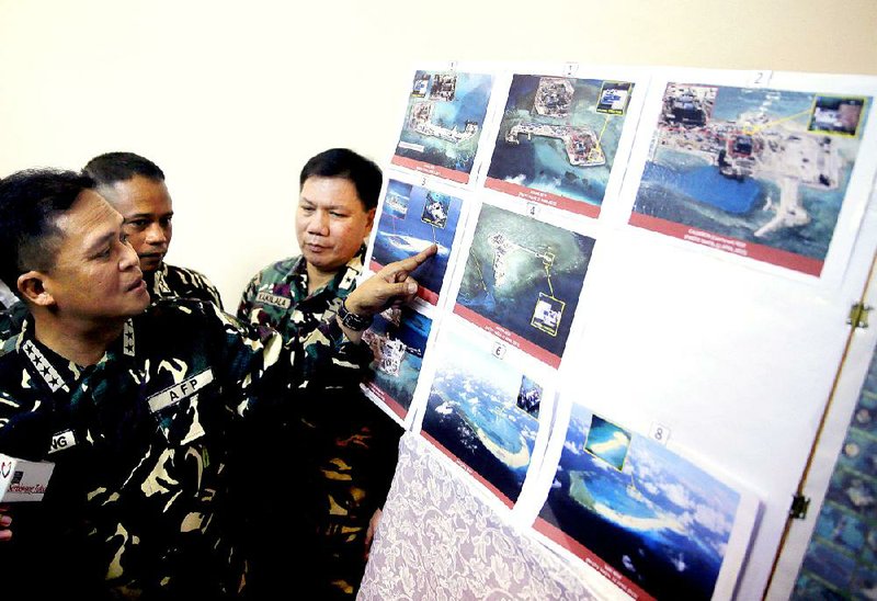 Armed forces of the Philippines Chief of Staff Gen. Gregorio Pio Catapang points to reveal recent images of China's reclamation activities being done at the disputed islands in the South China Sea during a news conference Monday, April 20, 2015 at Camp Aguinaldo at suburban Quezon city, northeast of Manila, Philippines. Catapang said continued Chinese land reclamation activities on disputed territory in the South China Sea "will cause tensions among claimant countries" and called for them to stop. In the past year, China has conducted massive land reclamation on previously submerged reefs in the South China Sea, or the West Philippine Sea, despite a U.S. call for a freeze on such construction to give time for diplomacy to work between China and its neighbors in Southeast Asia. (AP Photo/Bullit Marquez)