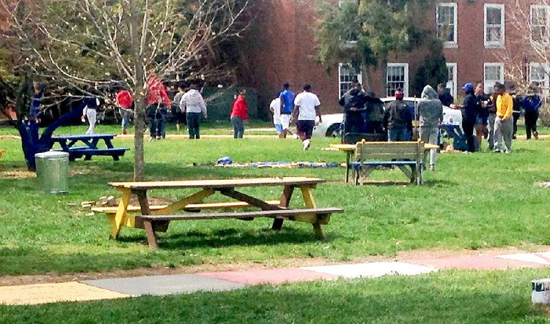 Students at Delaware State University disperse Sunday morning, April 19, 2015,  after cleaning up the area where three people were shot and injured Saturday during a university-sanctioned cookout on campus in Dover, Del. Authorities are searching for the shooter. DSU President Harry L. Williams said students have been told to stay inside their dormitories. Non-students were asked to leave campus. A second shooting occurred early Sunday at an apartment complex just off campus, but no one was injured.  (AP Photo/Randall Chase)