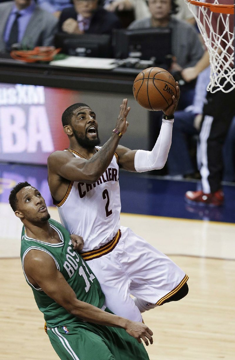 Cleveland guard Kyrie Irving drives to the basket past Boston’s Evan Turner (11) in the first quarter of the Cavaliers’ victory Tuesday in Cleveland. LeBron James scored 30 points and Irving added 26 as the Cavaliers took a 2-0 lead in their NBA Eastern Conference series. 