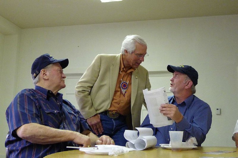 Bill John Baker (center), principal chief of the Cherokee Nation, talks with brothers Jerry Burrough, (left), and Darrell Burrough of Mountainburg at a campaign stop in Fayetteville on Monday night. Baker, who is running for re-election, has been campaigning in Northwest Arkansas because of the large number of tribal members who live there and vote absentee ballots. 