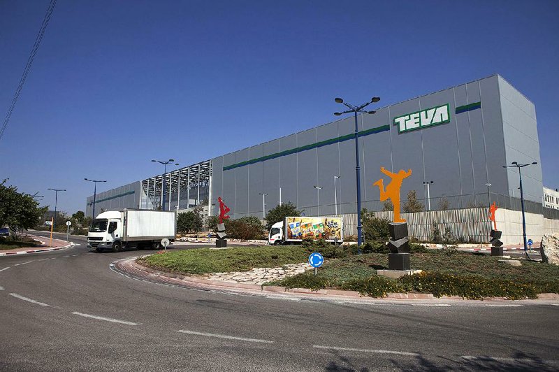 Trucks pass a Teva Pharmaceutical warehouse in Shoam, Israel, in this file photo. Teva on Tuesday formally offered to buy fellow drugmaker Mylan for about $40.1 billion in cash and stock.