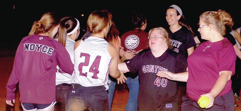 MARK HUMPHREY ENTERPRISE-LEADER Lincoln softball players shake hands with Gentry junior Mekalah Ramsey, 17, a Down syndrome junior varsity player, escorted by Lincoln junior varsity coach Megan Jobe holding the softball Mekalah hit, which Lincoln gave to her as a memento of her walk-off home run to cap the Pioneers&#8217; final at-bat.