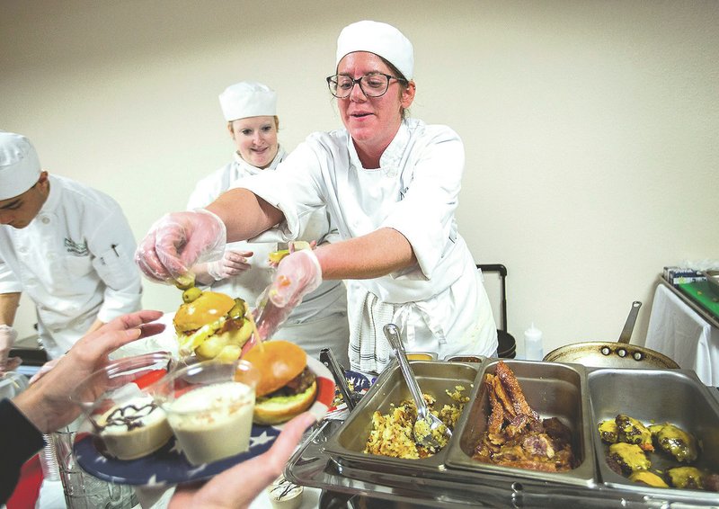 Megan Templeton, culinary arts student, serves burger samples Wednesday to visitors during a cook-off between students in Northwest Arkansas Community College’s culinary arts program at the Center for Non-profits in Rogers in April. The program announced Aug. 11 that it was expanding and relocating to Bentonville.