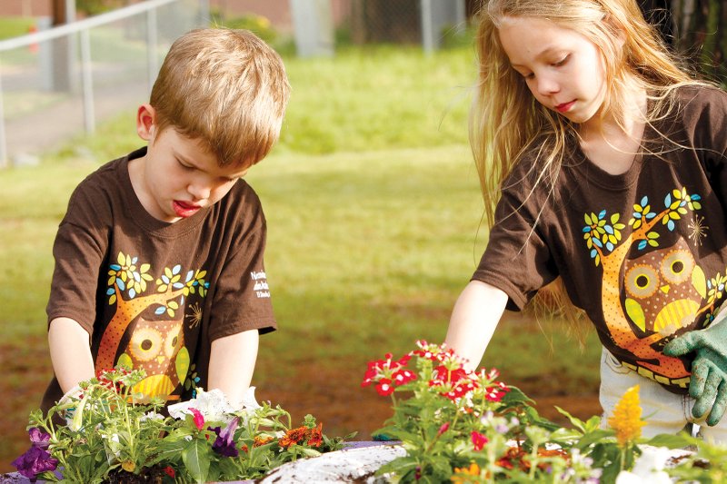 Earth Day activity: Northwest Elementary students Reid Sullivant, 5, and Macie Reed, 8, help construct a flower bed for an Earth Day celebration on Wednesday.