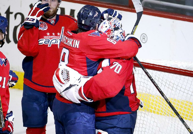 Washington Capitals left wing Alex Ovechkin (8), from Russia, embraces goalie Braden Holtby (70) as they celebrate after Game 5 in the first round of the NHL hockey Stanley Cup playoffs, Thursday, April 23, 2015, in Washington. The Capitals won 5-1.(AP Photo/Alex Brandon)