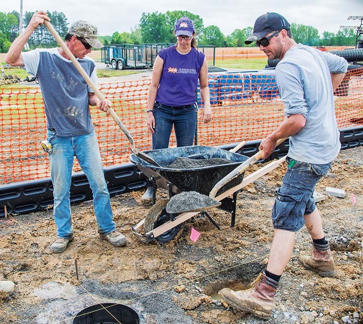 Rachel Malkusak, center, watches Oles Jones, left, and Todd Mazza shovel gravel around a form that will support a funnel-tube slide and a cliffhanger piece for the new playground in Vilonia City Park. The playground was paid for by Kimberly-Clark of Conway, the community partner for KaBoom! — a nonprofit organization. The park replaces one destroyed by the April 27, 2014, tornado. A baseball complex is ready to be bid for the site, too, Vilonia Mayor James Firestone said.