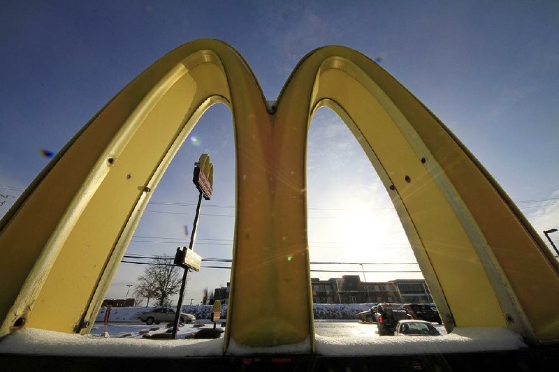 FILE - This Jan. 21, 2014 file photo, cars drive past the McDonald's Golden Arches logo at a McDonald's restaurant in Robinson Township, Pa. 