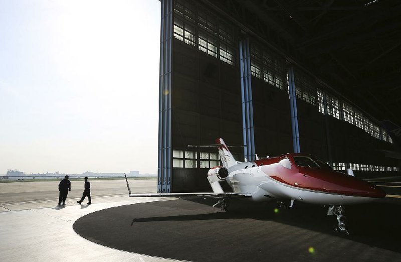 The HondaJet parks at a hangar at Tokyo's Haneda airport Thursday, April 23, 2015. Honda, known for making motorcycles and cars, is showing its new sleek business jet in Japan for the first time, billing it as quiet, quick and green. (AP Photo/Eugene Hoshiko)