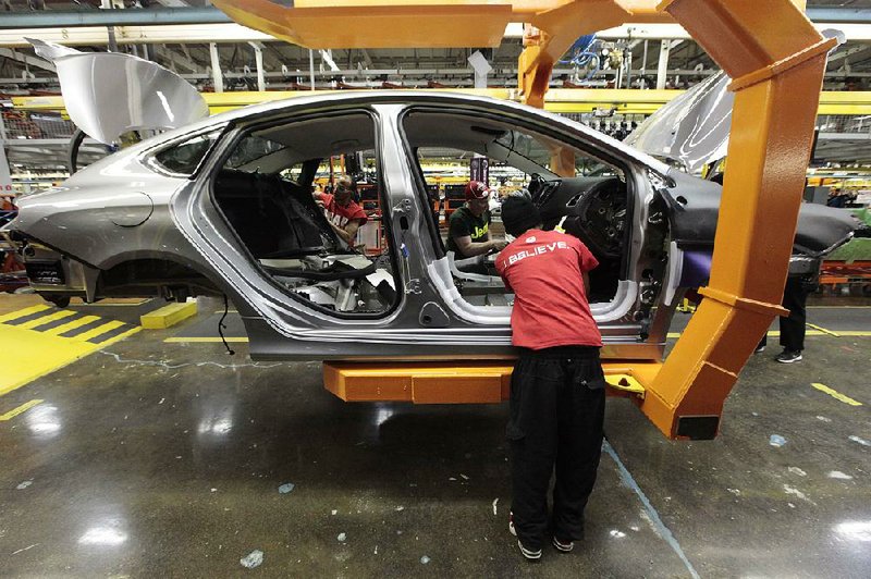 FILE - In this March 14, 2014 photo, assembly line workers build a 2015 Chrysler 200 automobile at the Sterling Heights Assembly Plant in Sterling Heights, Mich.  Lured by low wages and tax-saving free trade agreements, auto companies from the U.S. and overseas are accelerating plans to build new factories and add jobs in Mexico. The moves, part of a decade-long trend, are luring investments and work that could have gone to the U.S. and Canada, according to experts. But they also are likely to keep car and truck prices in check even as automakers add expensive fuel-saving features to meet U.S. gas mileage requirements. (AP Photo/Paul Sancya)