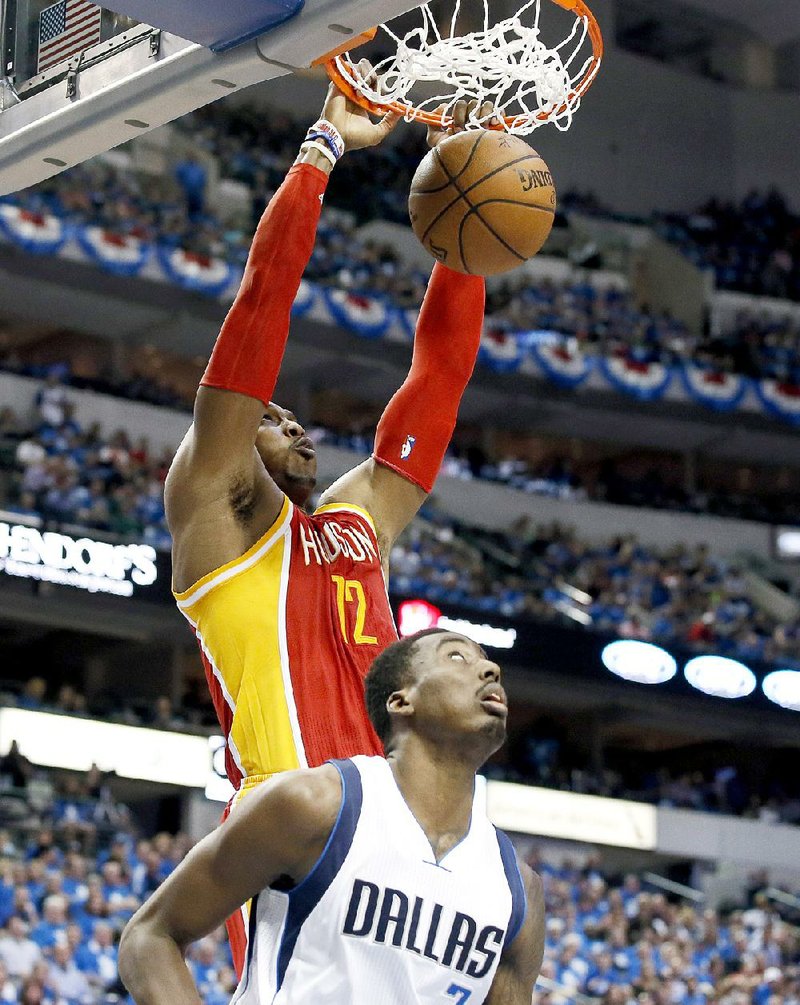 Houston Rockets' Dwight Howard (12) scores over Dallas Mavericks' Al-Farouq Aminu (7) during the first half of Game 3 in an NBA basketball first-round playoff series Friday, April 24, 2015, in Dallas. (AP Photo/Tony Gutierrez)