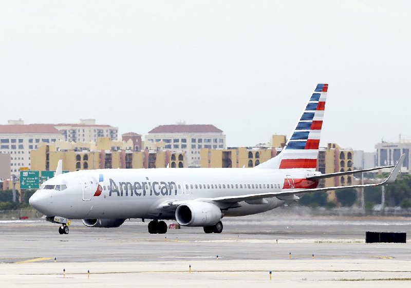 In this Wednesday, April 22, 2015 photo, an American Airlines Boeing 737 taxis before taking off at Miami International Airport in Miami. American Airlines reports earnings Friday April 24, 2015. (AP Photo/Wilfredo Lee)
