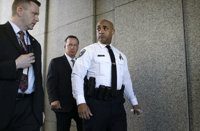 Baltimore Police Department Commissioner Anthony Batts, center, leaves a news conference after speaking about the investigation into Freddie Gray's death, Friday, April 24, 2015, in Baltimore. Gray died from spinal injuries about a week after he was arrested and transported in a police van. (AP Photo/Patrick Semansky)