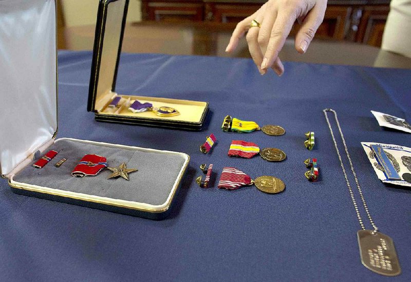 Arkansas Democrat-Gazette/MELISSA SUE GERRITS - 04/24/15 - Lauren Brewer, property controller with the Arkansas Auditor of State's office, describes medals at the State Capitol April 24, 2015. The medals and other unclaimed items in a deposit box were turned over to the state after being found in a Helena, Ark., bank. 