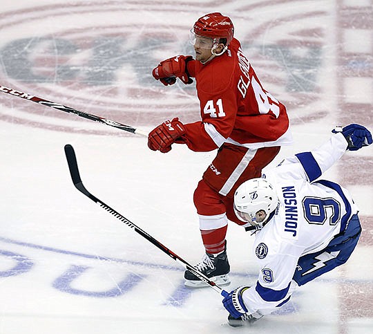 The Associated Press DOWN BUT NOT OUT: Detroit Red Wings right wing Luke Glendening checks Tampa Bay Lightning center Tyler Johnson (9) during the third period in Game 4 of a Stanley Cup Playoffs first-round series Thursday in Detroit. Johnson came back to score the tying goal late in regulation and the winner in overtime, lifting the Lightning to a 3-2 victory that knotted the best-of-seven series 2-2.