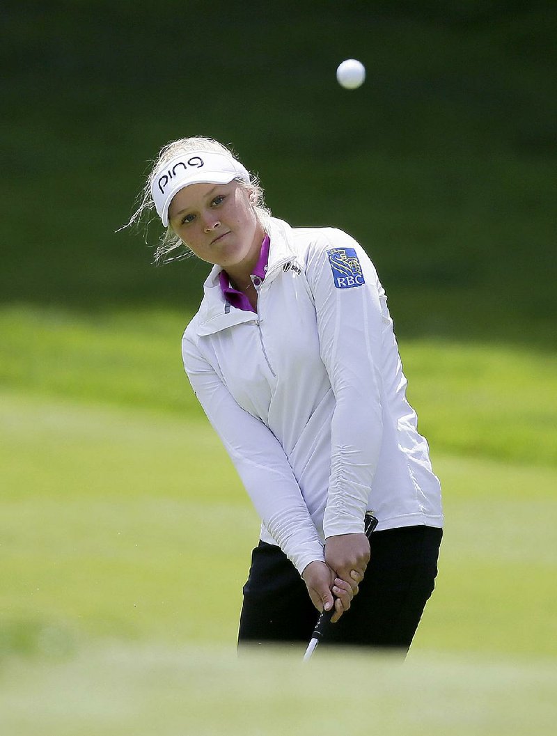 Brooke Henderson of Canada chips the ball onto the third green of the Lake Merced Golf Club during the third round of the Swinging Skirts LPGA Classic golf tournament Saturday, April 25, 2015, in Daly City, Calif. (AP Photo/Eric Risberg)