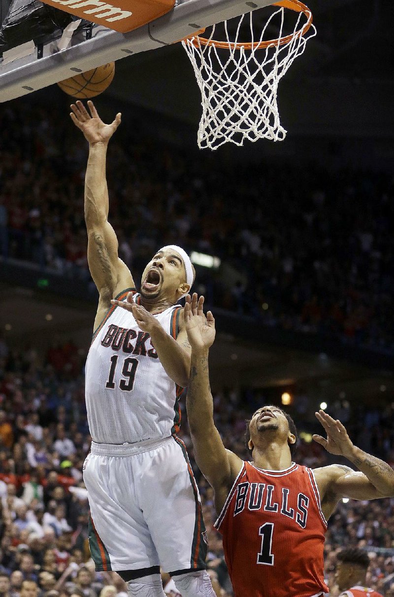 Milwaukee Bucks' Jerryd Bayless (19) puts up the game-winning shot against Chicago Bulls' Derrick Rose (1) during the second half of Game 4 of an NBA basketball first-round playoff series Saturday, April 25, 2015, in Milwaukee. The Bucks won 92-90. (AP Photo/Morry Gash)