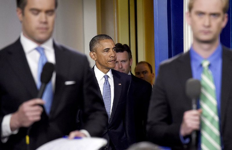 President Barack Obama, followed by White House press secretary John Earnest, walks into the Brady Press Briefing Room at the White House in Washington, Thursday, April 23, 2015, to make a statement. The president took full responsibility for deaths of American, Italian hostages, expresses apologies. (AP Photo/Susan Walsh)