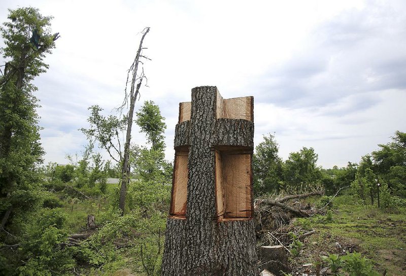 Arkansas Democrat-Gazette/STATON BREIDENTHAL --4/22/15-- A cross carved in a tree trunk marks an area in Mayflower that was damaged by last year's tornado. 