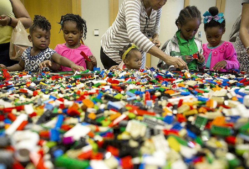Arkansas Democrat-Gazette/MELISSA SUE GERRITS - 04/25/15 - Jai White, 3, Sophie Moseby, 4, Grace Walker, 2, and her siblings Karl, 7, and Victoria 5, dig through a pile of lego's during a lego demonstration at the annual Arkansas Literary Festival April 25, 2015. The festival had a variety of opportunities for kids to participate with the lego demonstration highlighting kids ability to create by making their own unique designs and testing wheeled creations on a wooden track. 