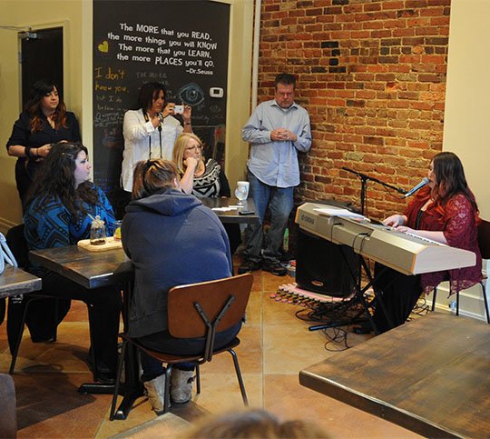 The Sentinel-Record/Mara Kuhn WELL VERSED: Featured poet Mary Buffington reads the original work "A Shade of Red"during Wednesday Night Poetry at Kollective Coffee+Tea. This was the first time WNP took place in its new venue.