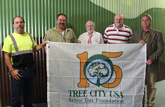 Submitted photo 15TH AWARD: Public Works Street Division Urban Forestry Crew Leader Freddy Padilla, left, Parks and Trails Landscape Superintendent Brian Fisher, Urban Forestry Advisory Committee member Byron Cole Rhodes, Urban Forestry Advisory Committee Chairman Jack Thorp, and Public Works Director Denny McPhate, display the flag sent by the Arbor Day Foundation to commemorate 15 consecutive years of Tree City USA designation. Not pictured are Urban Forestry Advisory Committee members John Simpson and Roger Carter.
