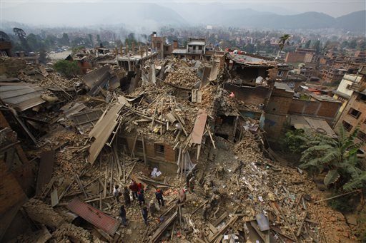 Rescue workers remove debris as they search for victims of earthquake in Bhaktapur near Kathmandu, Nepal, Sunday, April 26, 2015. A strong magnitude earthquake shook Nepal's capital and the densely populated Kathmandu Valley before noon Saturday, causing extensive damage with toppled walls and collapsed buildings, officials said. 