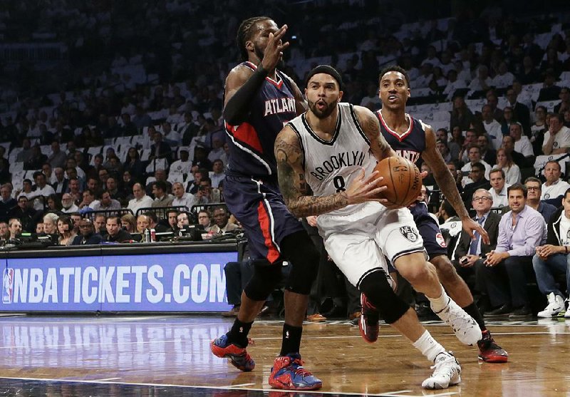 Brooklyn Nets guard Deron Williams (8) drives around Atlanta Hawks forward DeMarre Carroll (5) in the first quarter of Game 4 of a first round NBA playoff basketball game, Monday, April 27, 2015, in New York. (AP Photo/Kathy Willens)