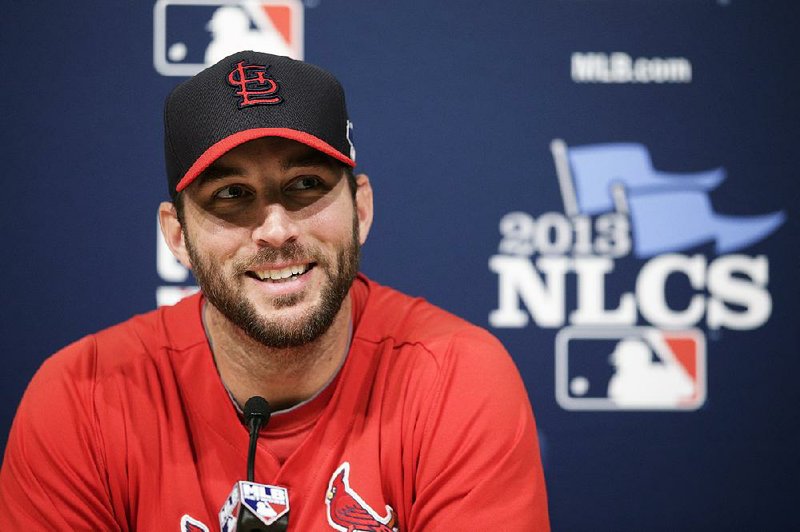 St. Louis Cardinals starting pitcher Adam Wainwright smiles while talking to reporters during practice in preparation for Monday's Game 3 of the National League baseball championship series against the Los Angeles Dodgers, on Sunday, Oct. 13, 2013, in Los Angeles. (AP Photo/Jae C. Hong)