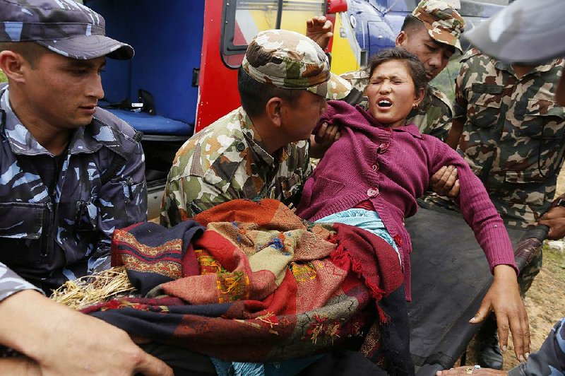 Sita Karka, suffering from two broken legs after Saturday’s earthquake, arrives by helicopter from heavily damaged Ranachour village, at a landing zone in Gorkha, Nepal, on Tuesday. 