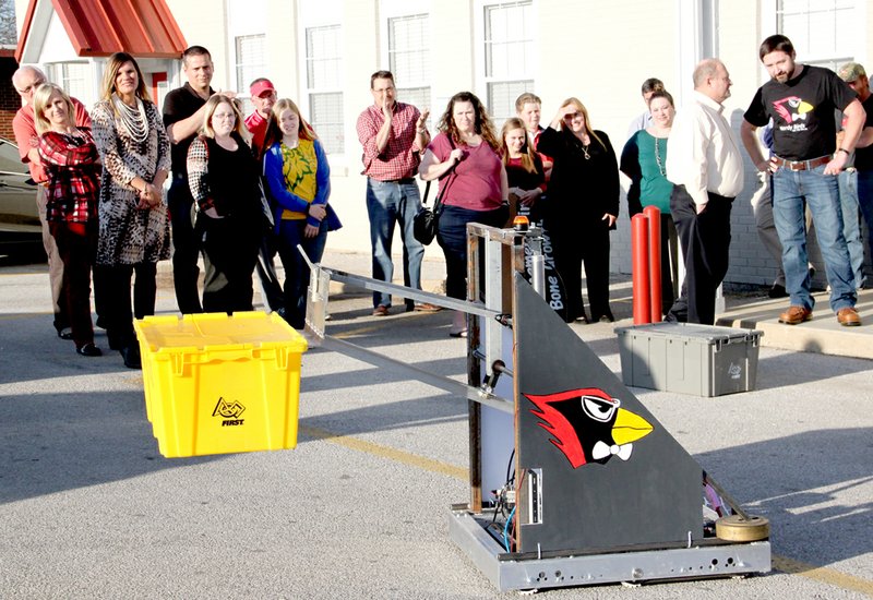 LYNN KUTTER ENTERPRISE-LEADER Farmington High&#8217;s robotics team demonstrates its robot to School Board members, administrators and others attending the March 31 board meeting. The objective was to build a robot that would pick up plastic totes and stack them as quickly as possible. The name of the robotics team is the Nerdy Birds.