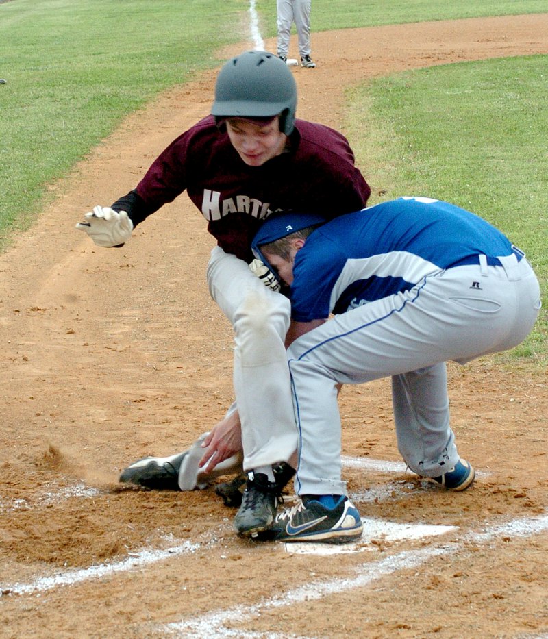 Photo by Mike Eckels Decatur pitcher Jay Porter tags a Hartford runner out at home plate during the Bulldog and Hustler baseball game April 23 at Edmiston Park. The runner was ejected from the game for standing up on the play. Porter sustained a slight cut to the forehead but was able to continue to play.