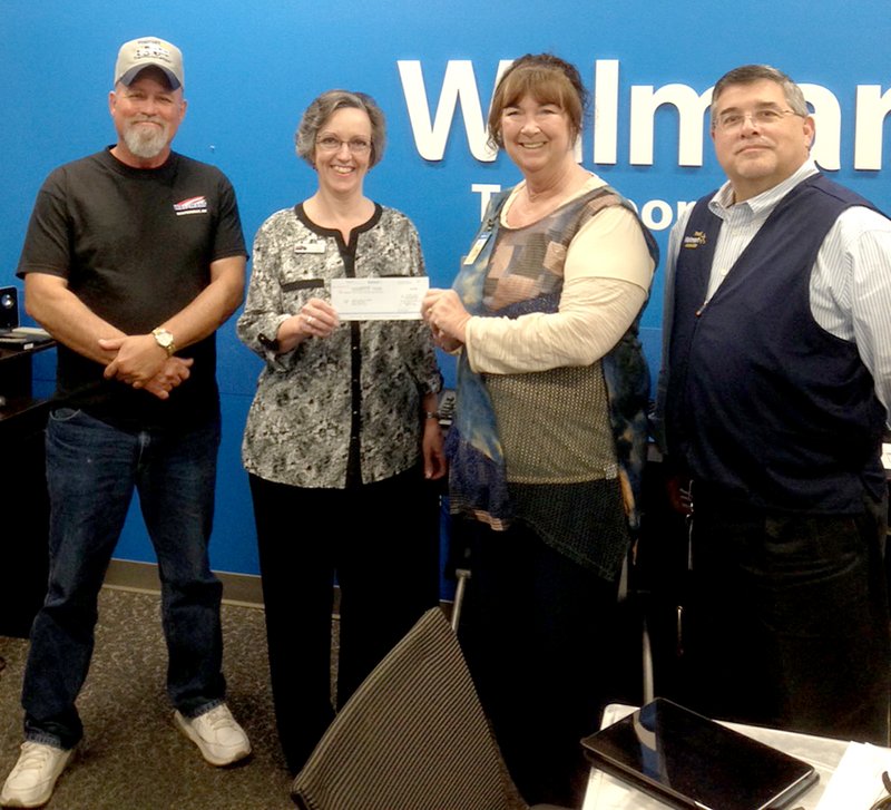 Submitted Photo Walmart Transportation-6801 presented the Gentry Public Library with a check for $848 for the purchase of a new outdoor bench to be placed on the west side of library building. Pictured at the check presentation in Bentonville are Kenny Threet, Walmart driver; Darla Threet, Gentry librarian; Marla King, general transportation assistant; and Bob Dixon, general transportation manager.