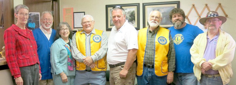Photo by Neka Lundquist Gravette Lions Club members gathered at Dr. Art Evans&#8217; dental clinic Monday to honor Lion member Lucia Greer, who died last year. Lucia was one of 16 Lions in District 7-1 who were remembered at a memorial service Saturday, April 18, at the state Lion convention in Searcy. A small blown-glass rose was given to Lucia&#8217;s family. Pictured are Susan Holland (left), who presented the rose; Dr. Art Evans and his wife Crow Johnson Evans, Lucia&#8217;s son-in-law and daughter; and Lion members Bill Mattler, Ken Foxx, Jeff Davis, Byron Warren and Larry Jones.