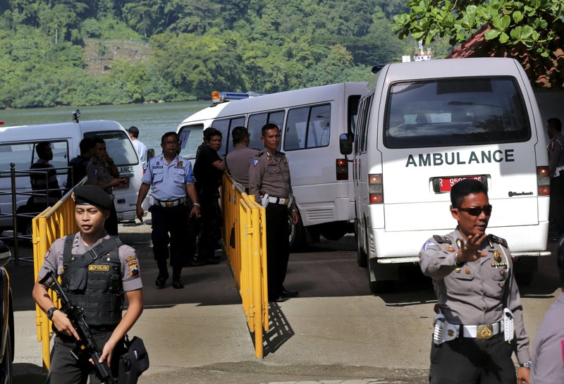 Armed police officers and security personnel stand guard as a ferry carrying ambulances prepares to set off for Nusakambangan island in Cilacap, Central Java, Indonesia, Tuesday, April 28, 2015. Indonesia notified nine foreigners and a local man convicted of drug trafficking over the weekend that their executions will be carried out within days, ignoring appeals by the U.N. chief and foreign leaders to spare them.