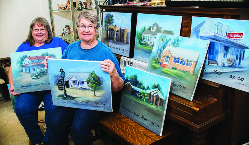 Vilonia artists Carol Wharton Stroud, left, and Jan Crummer show some paintings of buildings in and around Vilonia that they have re-created on canvas. The artists have donated the collection — A Walk Down Main Street, and More — to the city of Vilonia and will be honored at a reception from 2-4 p.m. Sunday at Vilonia City Hall. The public is invited.