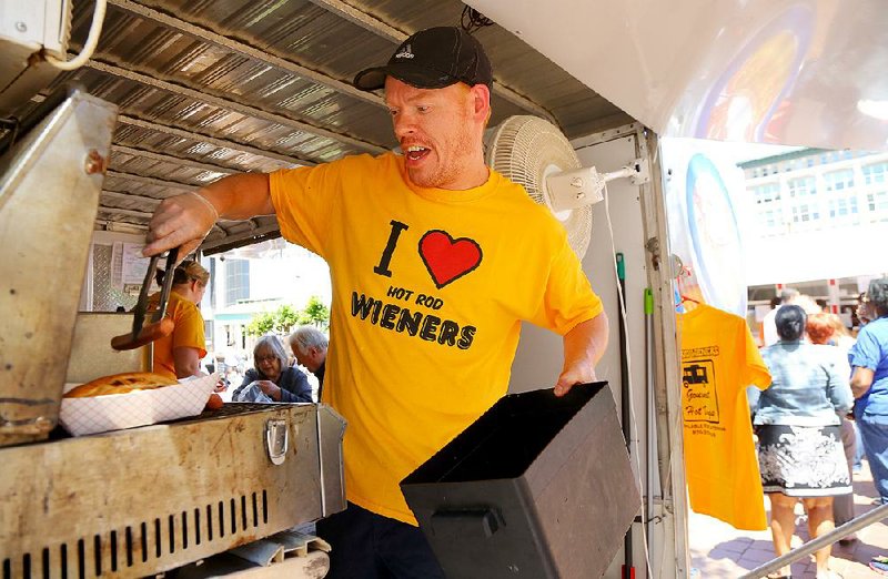 Arkansas Democrat-Gazette/STEPHEN B. THORNTON
Justin Wilson pulls hot dogs off the grill as he cooks for patrons in his Hot Rod Wieners truck during Main Street Food Truck Fridays at Capitol Ave. and Main Street in downtown Little Rock in May. 