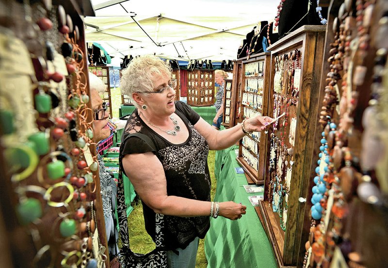 NWA Democrat-Gazette/BEN GOFF Kimberly Spencer (right) and friend Linda Wilson from Sand Springs, Okla., look Friday at jewelry in the booth of Nature&#8217;s Gems, from Kearney, Mo., at the Spanker Creek Farm Arts &amp; Craft Fair in Bentonville. For photo galleries, go to nwadg.com/photos.