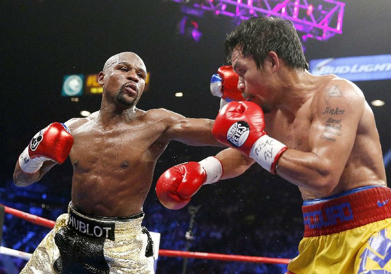 Floyd Mayweather Jr., left, lands a left against Manny Pacquiao, from the Philippines, during their welterweight title fight on Saturday, May 2, 2015 in Las Vegas. (AP Photo/John Locher)