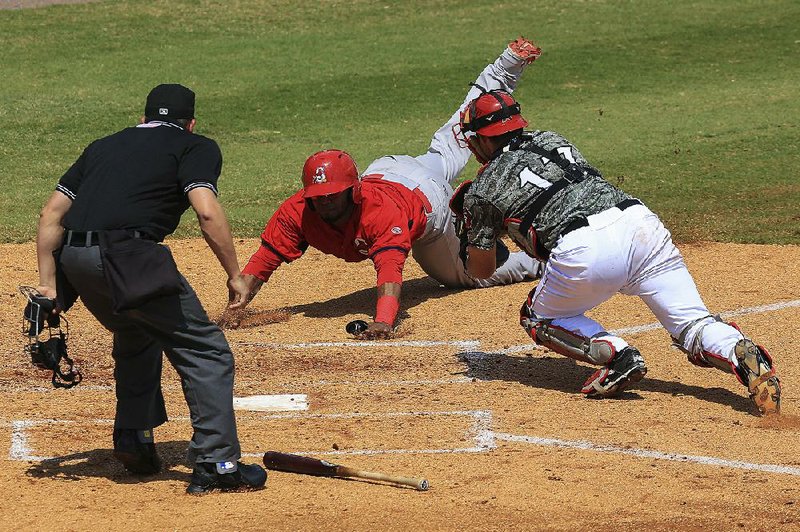 Arkansas Democrat-Gazette/STATON BREIDENTHAL --5/3/15-- Arkansas Travelers catcher Charlie Cutler (right) moves to make a tag on Springfield base runner Anthony Garcia Sunday afternoon during the Travelers game at Dickey-Stephens Park. Garcia was called safe on the play. 