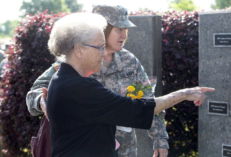 Arkansas Democrat-Gazette/MELISSA SUE GERRITS - 05/03/15 - Billie Warren is helped by sergeant Susan Sharpe to the memorial plaque for her son, William T. Warren April 3, 2015 at Camp Robinson's Fallen Soldiers Memorial during a memorial service at Camp Robinson. The service honored the memory of 20 Arkansans killed during Operation Iraqi Freedom, as well as Guard members and militia predecessors killed in wars dating back to the War of 1812.