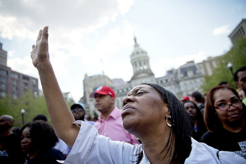 Patricia Freeman prays during a rally in front of City Hall, Sunday, May 3, 2015, in Baltimore. Hundreds of jubilant people prayed and chanted for justice days after the city's top prosecutor charged six officers involved in Freddie Gray's arrest. Gov. Larry Hogan has called for a statewide "Day Of Prayer And Peace" on Sunday after civil unrest rocked Baltimore. (AP Photo/David Goldman)