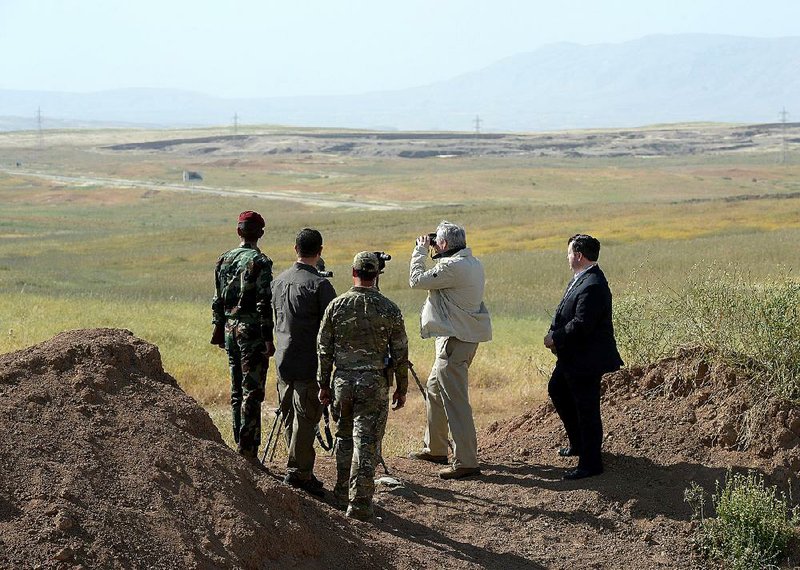 Prime Minister Stephen Harper, second from right, and Minister of Defence Jason Kenney, right look out towards active ISIL fighting positions as he visits members of the Advise and Assist mission 40 km west of Erbil, Iraq, on Saturday, May 2, 2015.   (Sean Kilpatrick/The Canadian Press via AP) MANDATORY CREDIT
