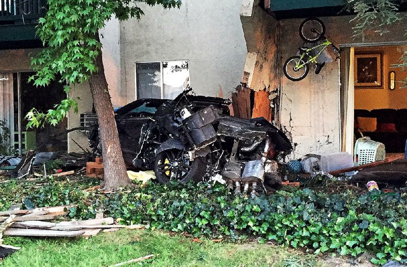 This Saturday, May 2, 2015, photo provided by the Livemore, Calif., Police Department shows the scene after a car crashed into an apartment complex, killing a woman and toddler and slightly injuring two other children, in Livermore in Northern California. Police arrested Brian Jones, of Livermore on suspicion of gross vehicular manslaughter while intoxicated and another alcohol-related driving count, Officer Ryan Sanchez said. (Ryan Sanchez/Livermore Police Department via AP)