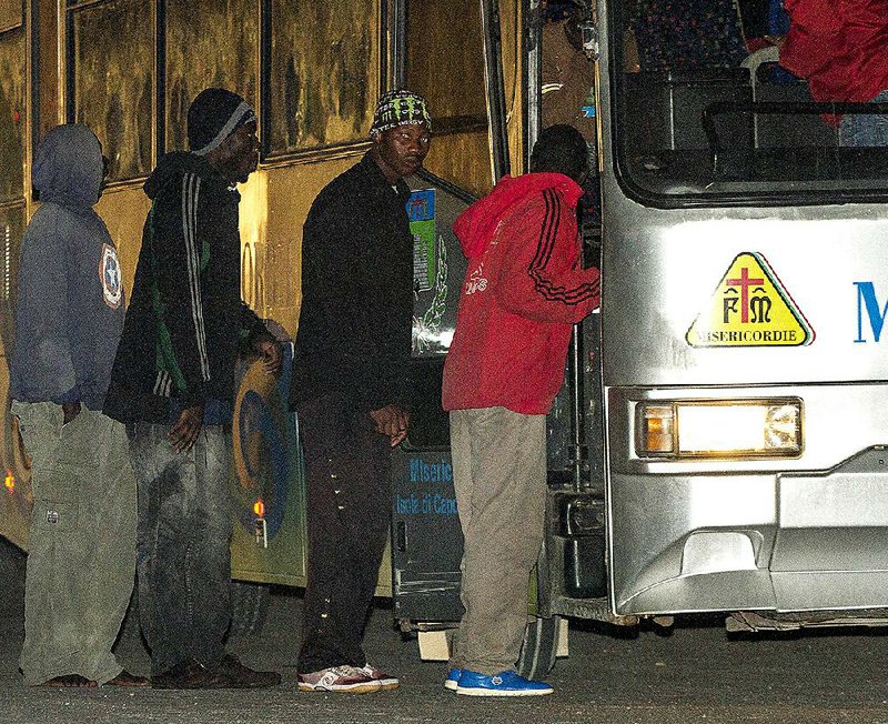 Migrants board a bus after arriving at the Lampedusa island early Sunday, May 3, 2015. Ships rescued 3,690 migrants in just one day from smugglers' boats on the Mediterranean Sea off the Libyan coast, the Italian Coast Guard said Sunday. The agency said 17 different rescue operations were carried out Saturday after smugglers took advantage of calm seas and warm weather to move the migrants out of Africa on motorized rubber dinghies and fishing boats. The relentless flood of migrants is continuing this year after 170,000 were rescued at sea by Italy in 2014 — a 277 percent increase over the numbers in 2013. (AP Photo/Mauro Buccarello)