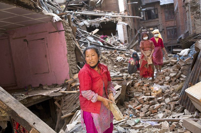 Nepalese women remove debris searching their belongings from their house that was destroyed a week ago during the earthquake in Bhaktapur, Nepal, Sunday, May 3, 2015. The true extent of the damage from the April 25 earthquake is still unknown as reports keep filtering in from remote areas, some of which remain entirely cut off. The U.N. says the quake affected 8.1 million people — more than a quarter of Nepal's 28 million people. (AP Photo/Bernat Amangue)