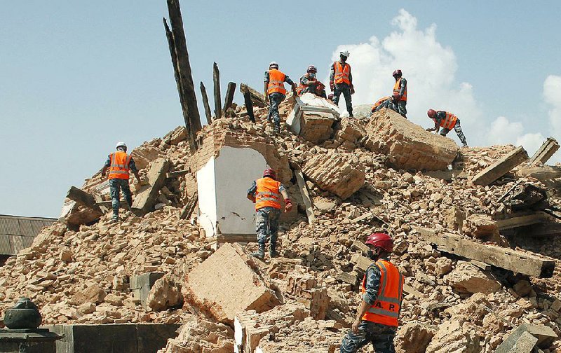 Nepalese soldiers clear the debris at the Kaalmochan temple in Kathmandu, Nepal, Saturday, May 2, 2015. A week after the devastating earthquake, life is limping back to normal in Nepal with residents visiting temples on the first Saturday after the quake, a day normally reserved for temple visits. (AP Photo/Niranjan Shrestha)