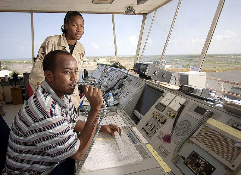 U.S. Air Force Tech Sgt. Monique Whitaker, back, works with Mahad Omar, a Djiboutian air-traffic controller, in 2007 at Camp Lemonnier, a U.S. military base adjacent to the airport. The U.S. military has sought to improve the performance and training of the Djiboutian air-traffic controllers, who are hired by the Djibouti government. Illustrates MILITARY-SAFETY (category a), by Craig Whitlock © 2015, The Washington Post. Moved Thursday, April 30, 2015. (MUST CREDIT: Photo by Master Sgt. Scott Wagers/U.S. Air Force )