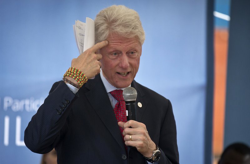 Former President Bill Clinton gestures while wearing a bracelet given to him by the pupils, as he and Chelsea Clinton talk about their foundation's "No Ceilings" project about the participation of women and girls globally, at the Farasi Lane Primary School in Nairobi, Kenya, on Friday, May 1, 2015. Former President Bill Clinton and daughter Chelsea Clinton are in the East African nation of Kenya as part of a wider tour of projects run by the family's Clinton Foundation. 