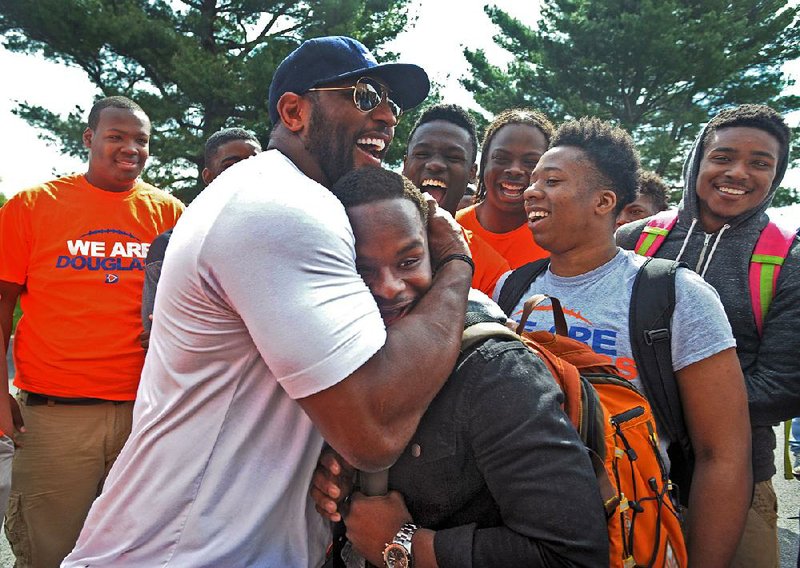 Former Baltimore Ravens NFL football player Ray Lewis hugs 17-year-old Azariah Bratton-Bey Jr., a senior running back on Frederick Douglass High's football team, during a visit to the school Thursday, April 30, 2015, in Baltimore. Lewis, Ravens coach John Harbaugh, and other players visited schools in downtown Baltimore in the aftermath of riots that ravaged the city. (Kenneth K. Lam/Baltimore Sun via AP) THE WASHINGTON EXAMINER OUT